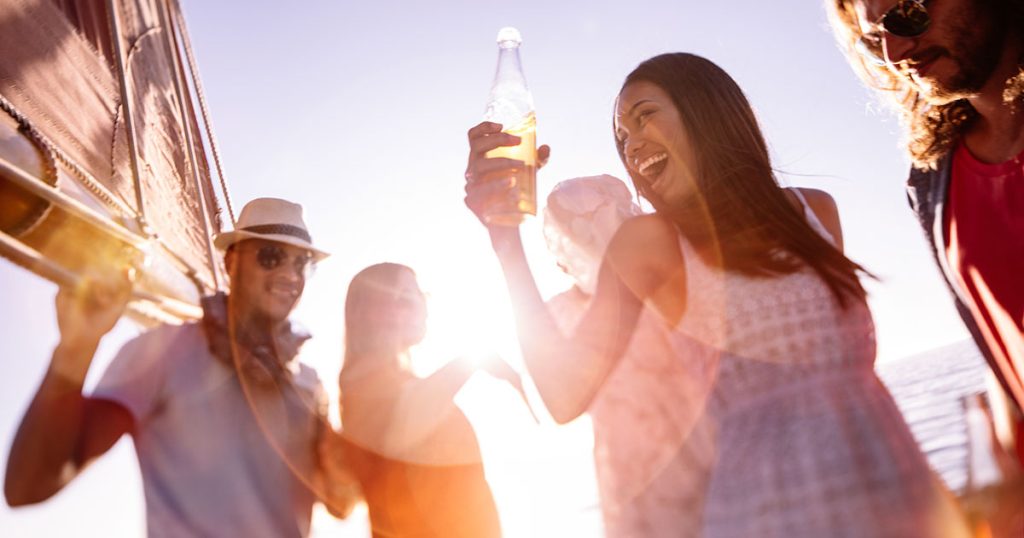 people celebrate on beach glass bottle