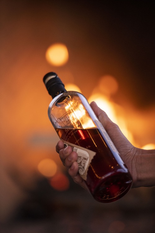 Transparent glass bottle containing a fine amber spirit