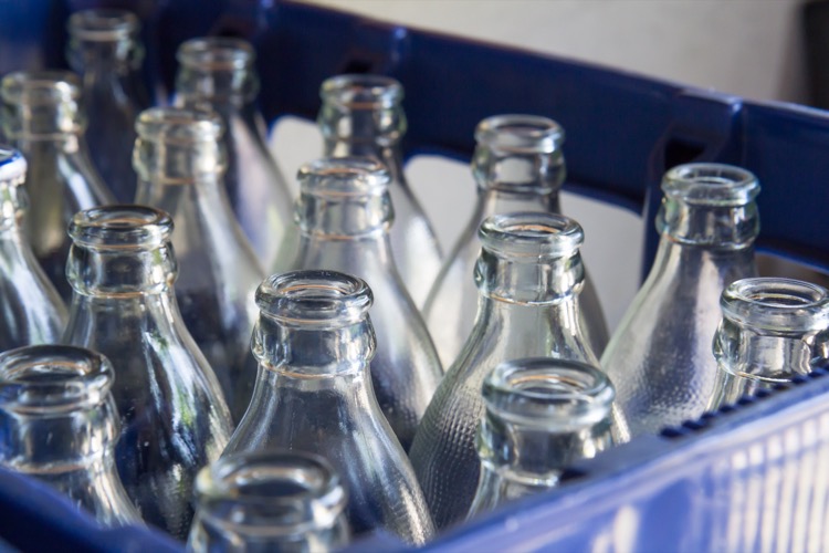 water glass bottles in blue plastic crate