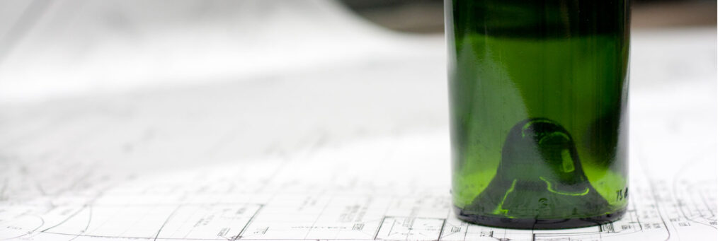 glass wine bottle and blue prints